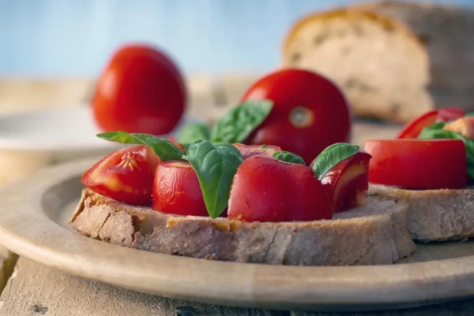 Panzanella romana con pomodori a pezzi e basilico su pane inzuppato di aceto.